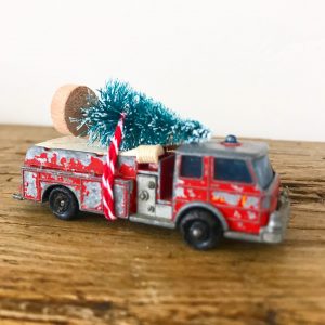 Charmingly shabby vintage fire engine with bottle brush tree